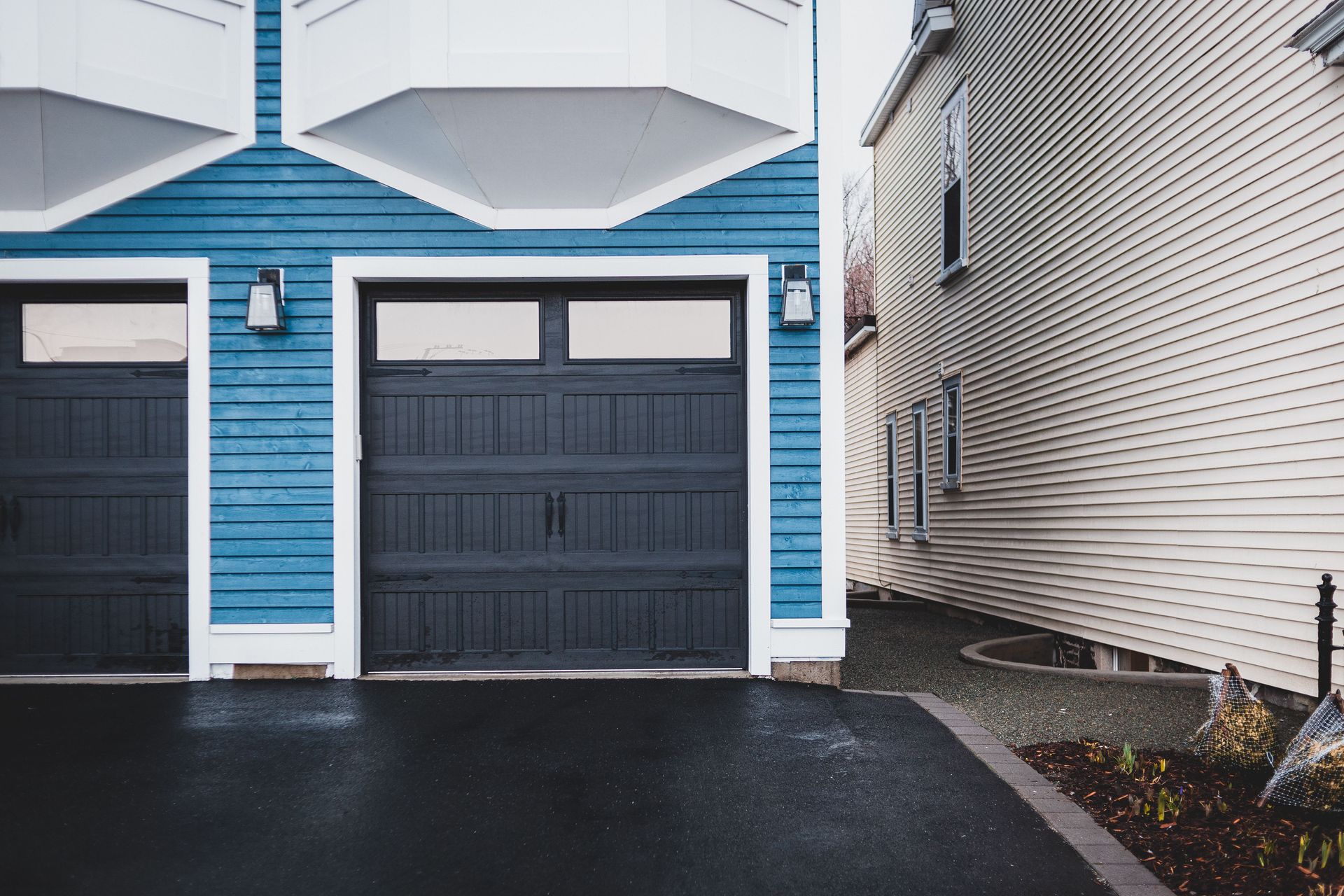 Exterior of contemporary residential building with wooden door and walls paneled blue and lights